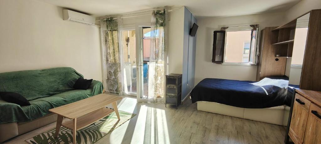 un salon avec un lit et un canapé dans l'établissement Modern seaside studio, à Fréjus