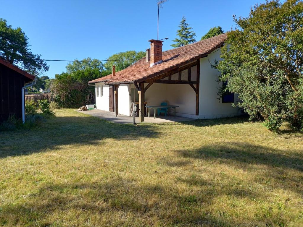 une petite maison blanche avec un toit sur une cour dans l'établissement Charming garden house, à Bias