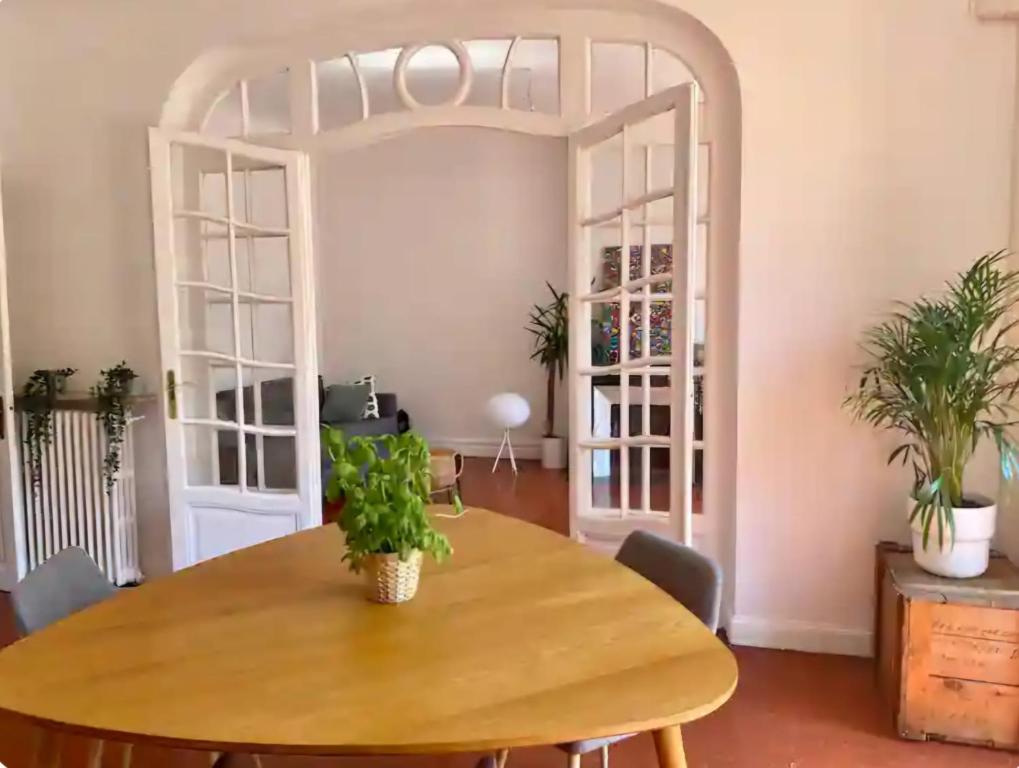 d'une salle à manger avec une table en bois agrémentée de plantes. dans l'établissement Au Passage Niçois, à Nice