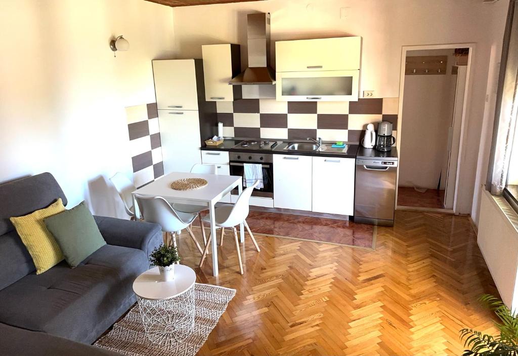 a living room with a couch and a table and a kitchen at Apartment Marino in Senj