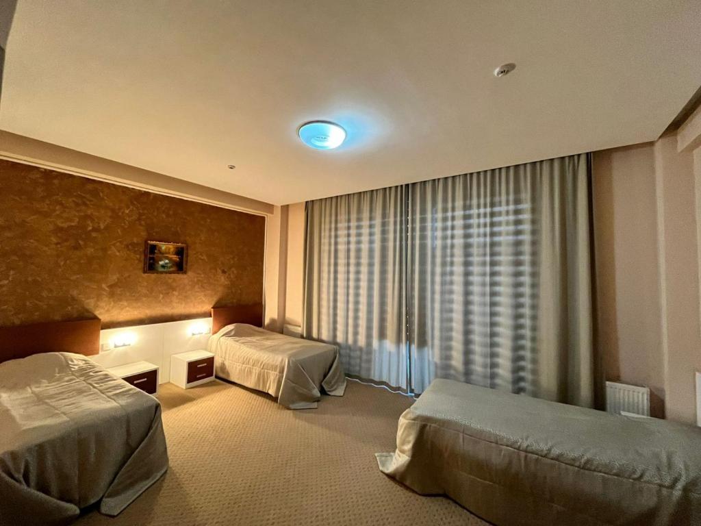 a hotel room with two beds and a window at Arena Hotel Dashkasan in Xoşbulaq