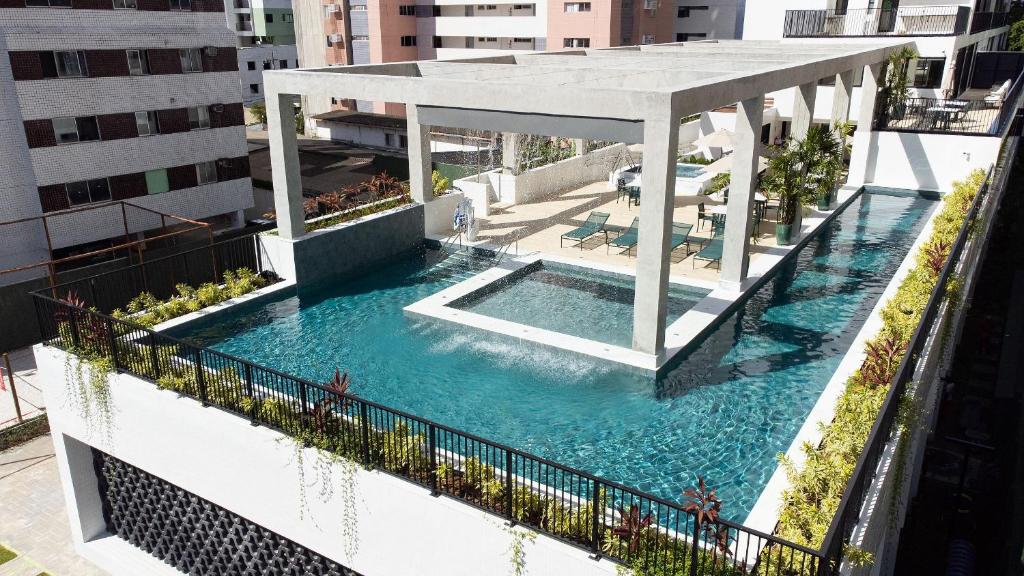 an outdoor swimming pool with a gazebo on a building at Tolive Riverside - High-Standard Studios in Recife by Carpediem in Recife