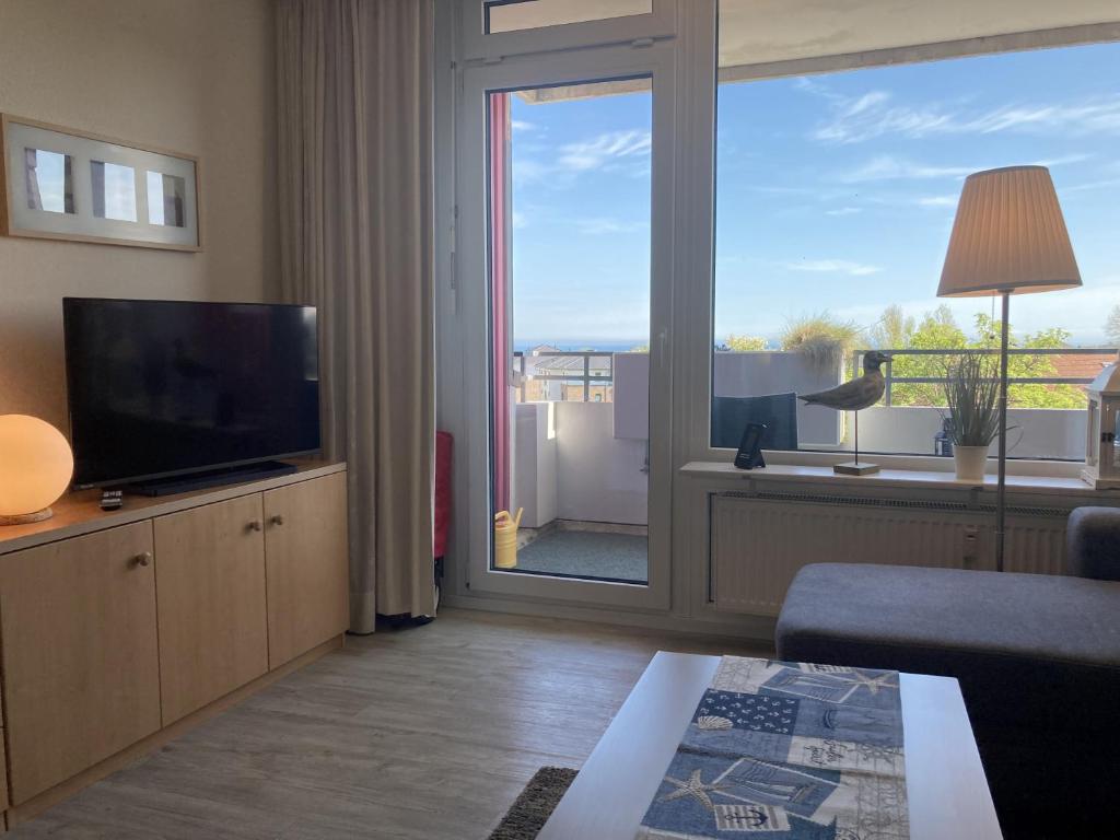 a living room with a television and a large window at Berolina 316 - Möwennest in Dahme