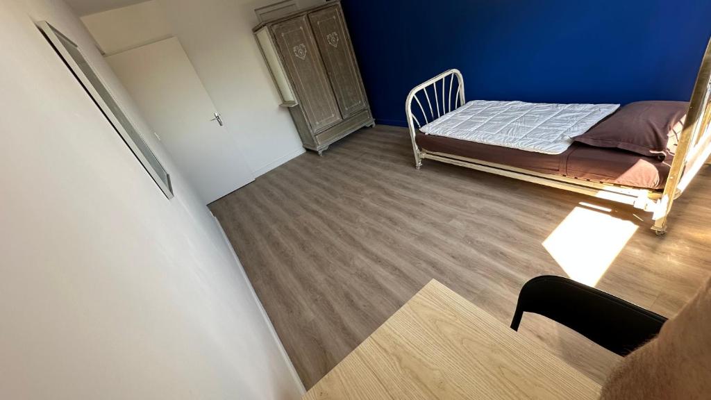 Cette petite chambre comprend un lit et un mur bleu. dans l'établissement Lyon Tassin appartement proche Métro bus parking possible, à Vaise