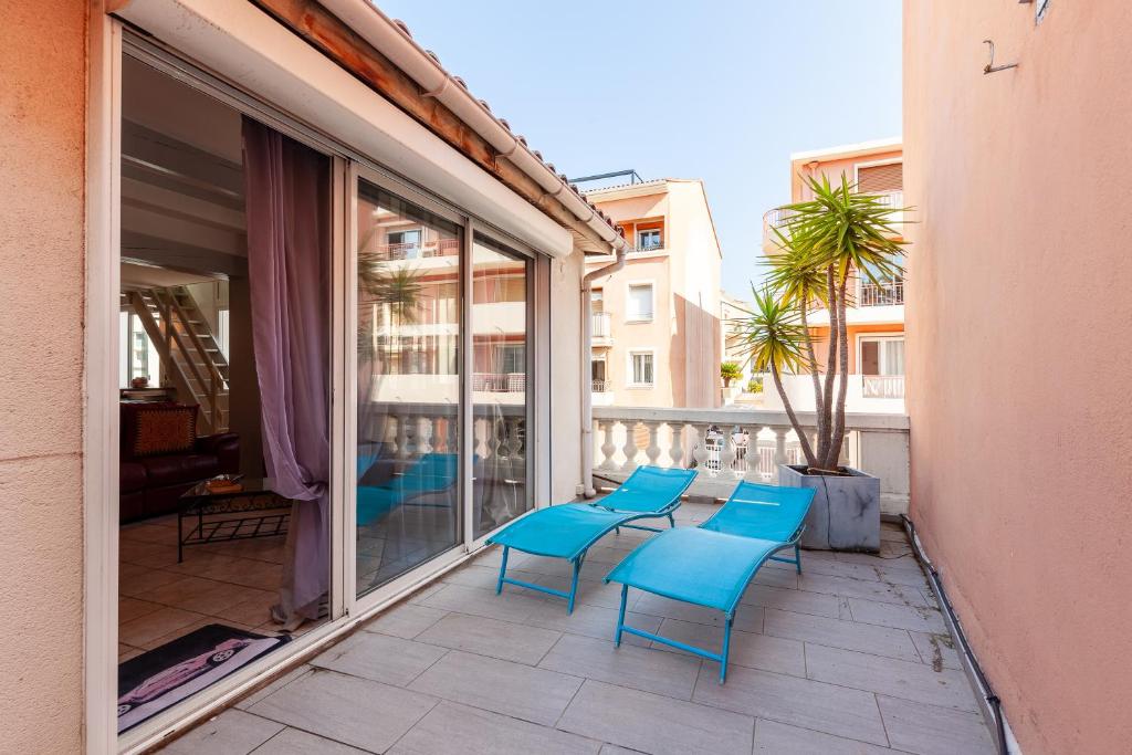 Un grupo de sillas azules en un balcón. en Appartement Spacieux, en Sanary-sur-Mer