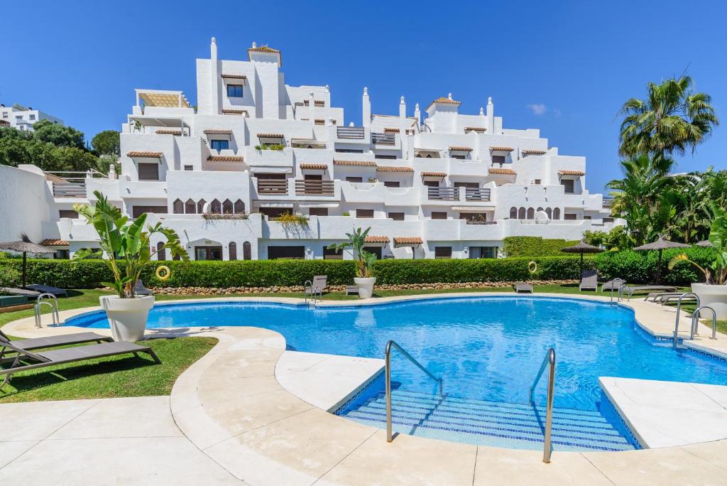 a large white building with a swimming pool in front of it at Golf Hills in Estepona