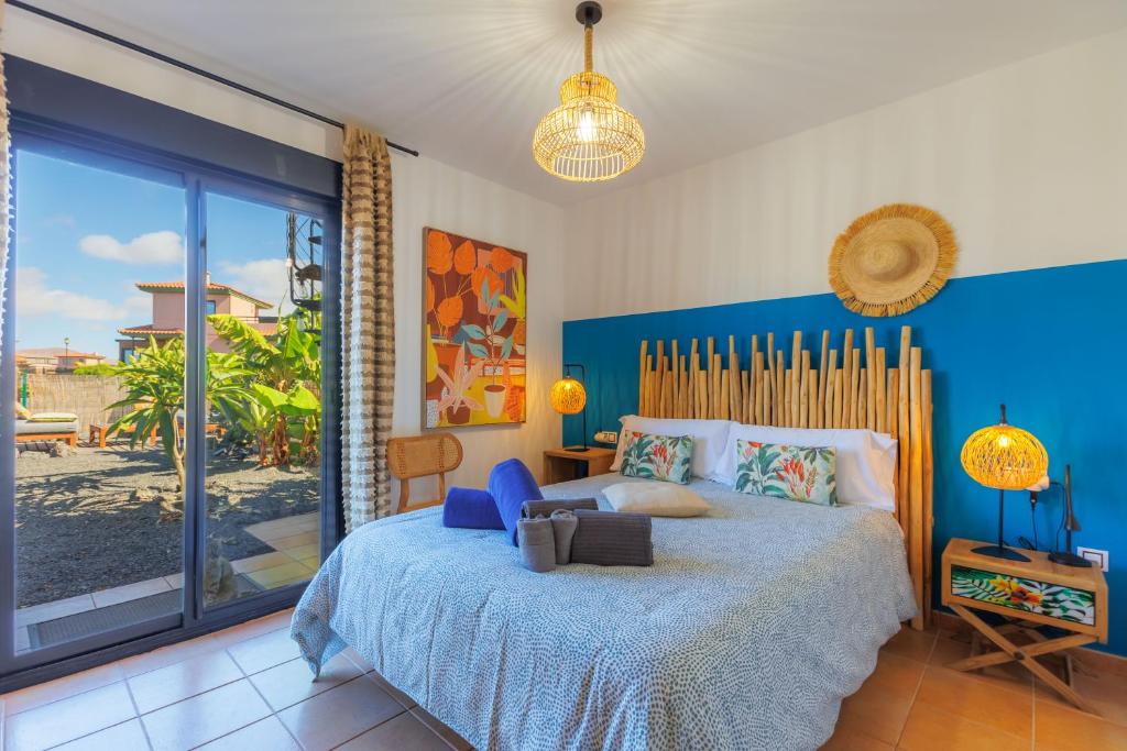 a bedroom with a large bed with a blue wall at Alma Ventura - A Peaceful Getaway in Majanicho in Majanicho
