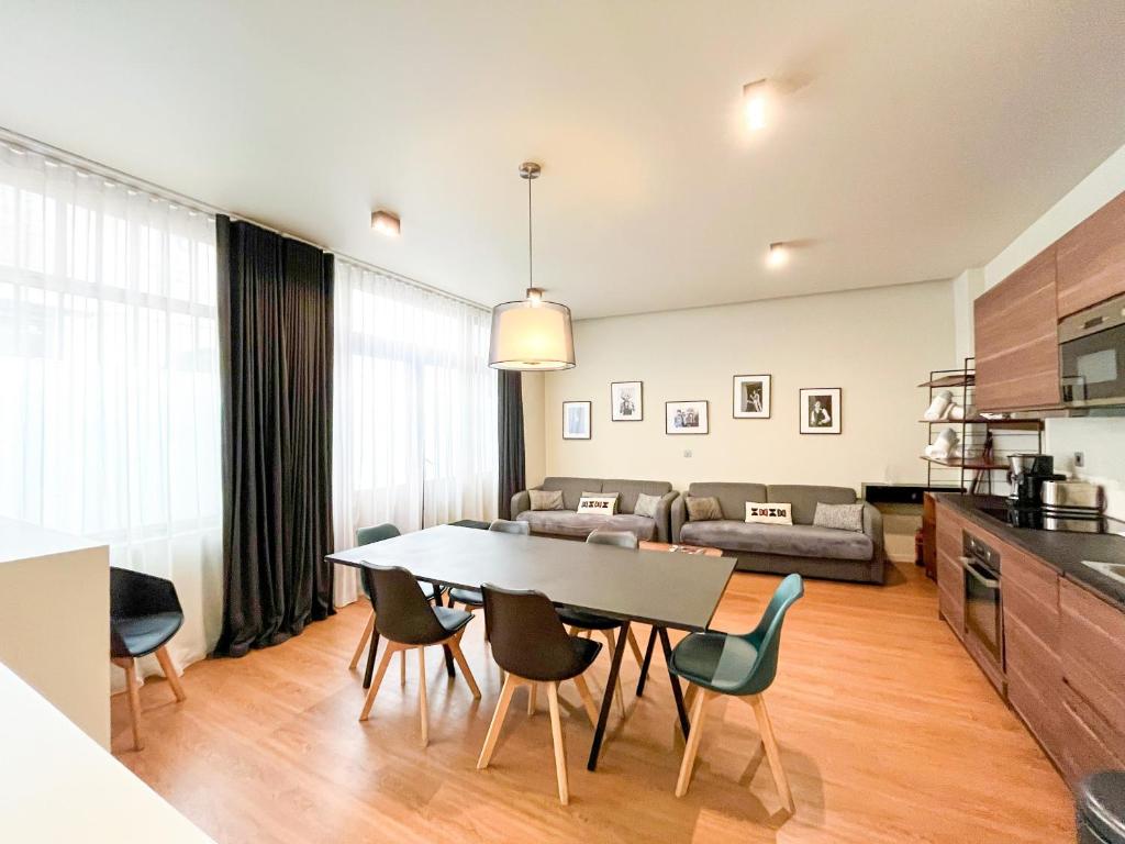une cuisine et un salon avec une table et des chaises dans l'établissement Urban Flat 138 - Beautiful Duplex in Saint Germain, à Paris