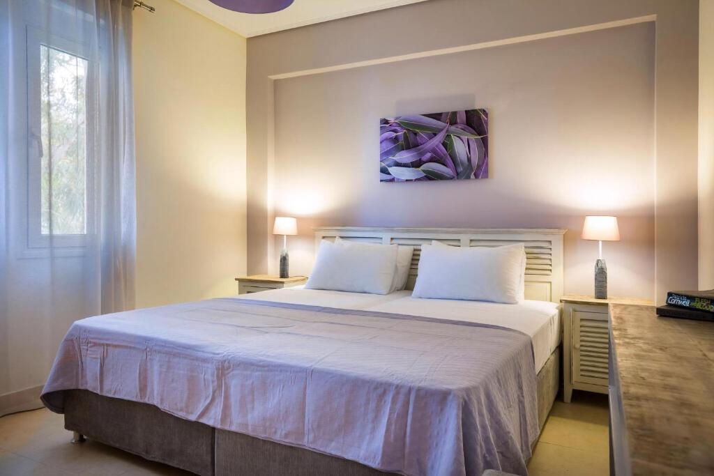 sypialnia z dużym białym łóżkiem z 2 poduszkami w obiekcie Deluxe Kefalonia Apartment Apartment Neroli 2 Bedroom Pool Karavomilos w mieście Karavomylos