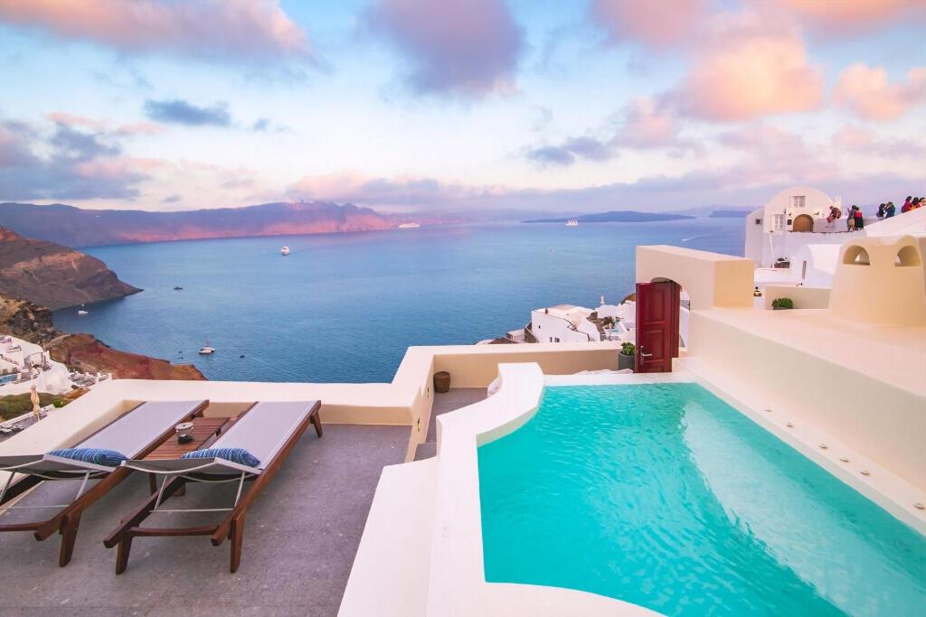 basen na boku budynku z widokiem na ocean w obiekcie Elegant Santorini Villas Villas Aloia Private Hot Tub Air Conditioning 1 Bedrooms Oia w mieście Oia