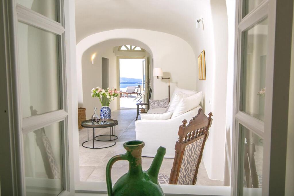 salon z białą kanapą i stołem w obiekcie Elegant Santorini Villas Villas Aloia Private Hot Tub Air Conditioning 1 Bedrooms Oia w mieście Oia