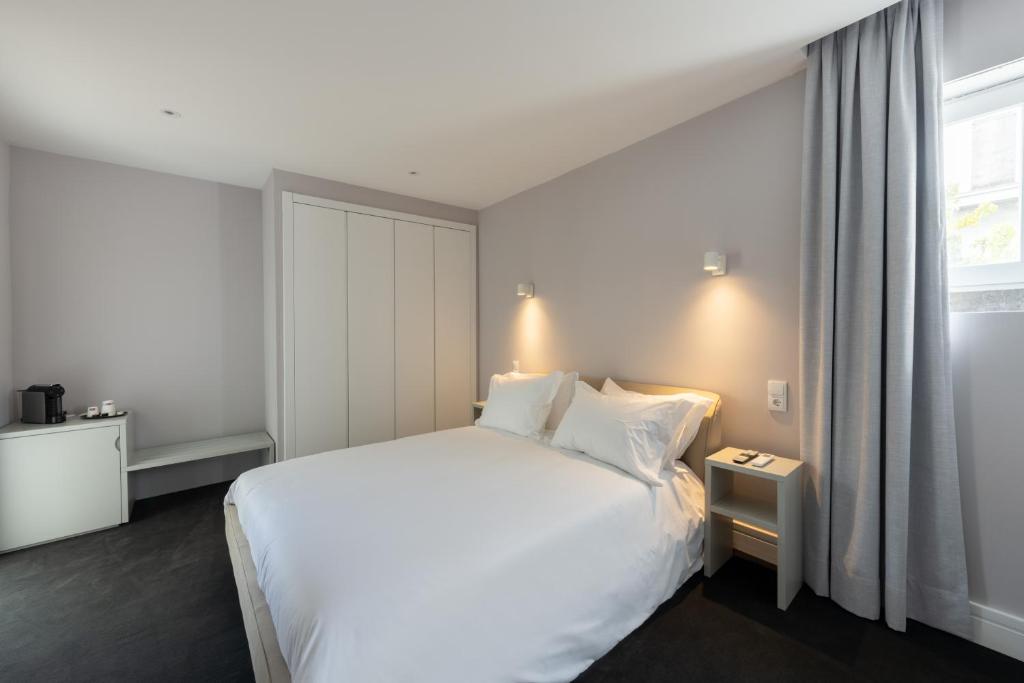A double bedroom with a large bed, wardrobe and a curtained window.