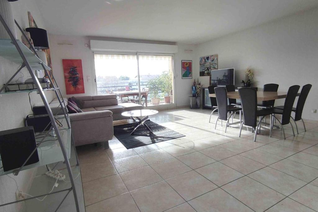 un salon avec un canapé, une table et des chaises dans l'établissement Spacious apartment for 6 with balcony, à Saint-Raphaël