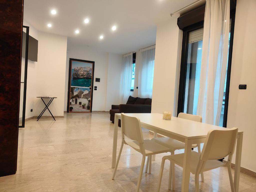 Una mesa de comedor y sillas en una sala de estar. en CconfortHotels eXtramurale Apartment, en Bari