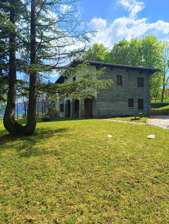 a house with a tree in front of a yard at Villa Giordani affittacamere Boscoreale in Piandelagotti