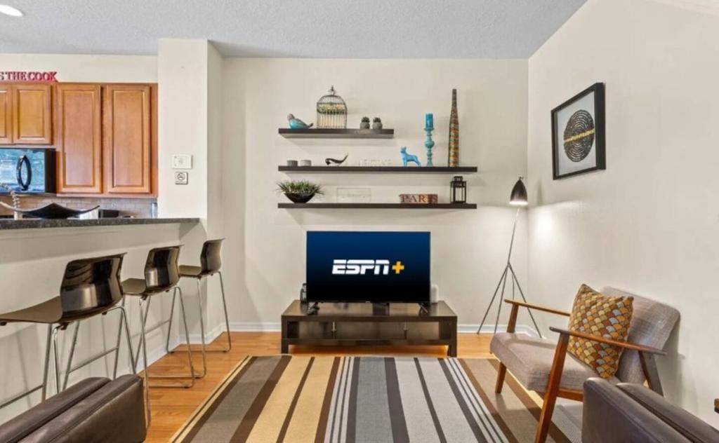 a living room with a tv and a bar at Lovely 3bd Home With Bbq in Orlando