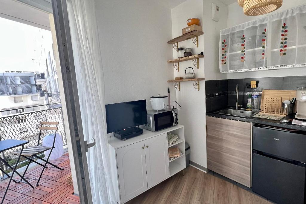 une petite cuisine avec un comptoir et un micro-ondes dans l'établissement Cosy studio for 2 persons, à Marseille