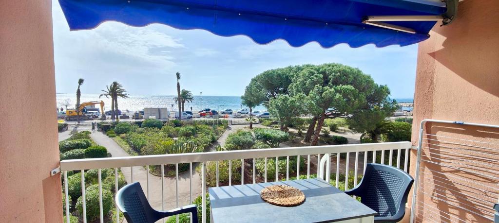 un balcon avec une table et des chaises et l'océan dans l'établissement 1 bedroom apartment - sea view, à Fréjus