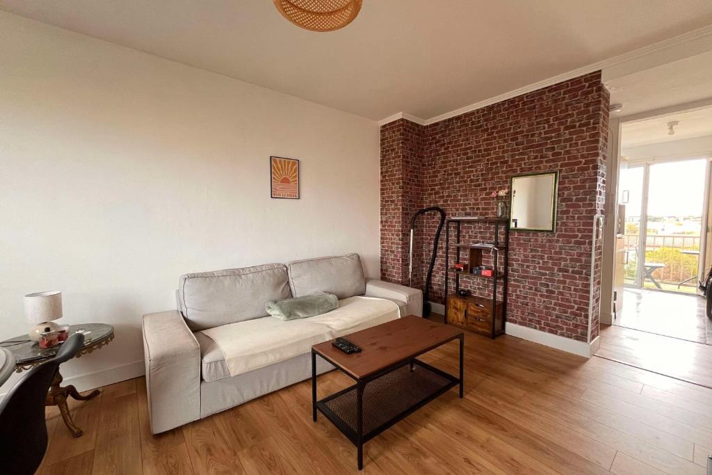 un salon avec un canapé et un mur de briques dans l'établissement Housing renovated of 68 m2 - Toulouse, à Toulouse
