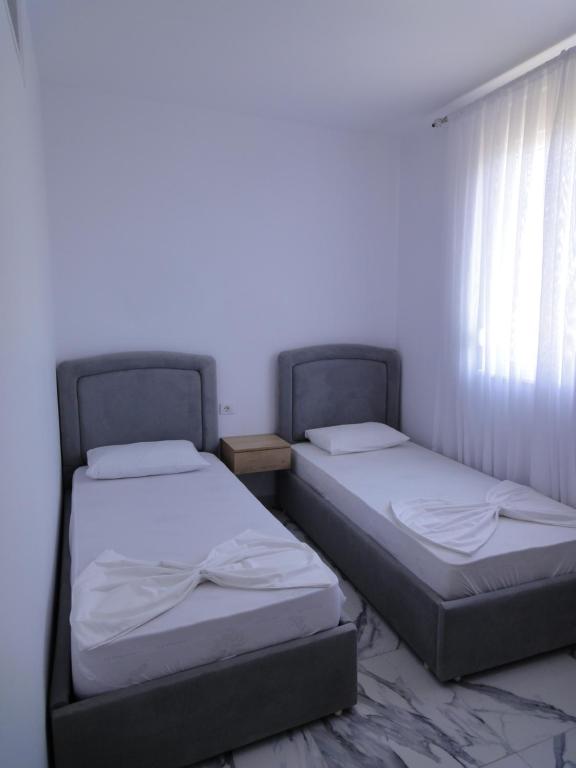 Postel nebo postele na pokoji v ubytování Niki Apartments Shen Gjin