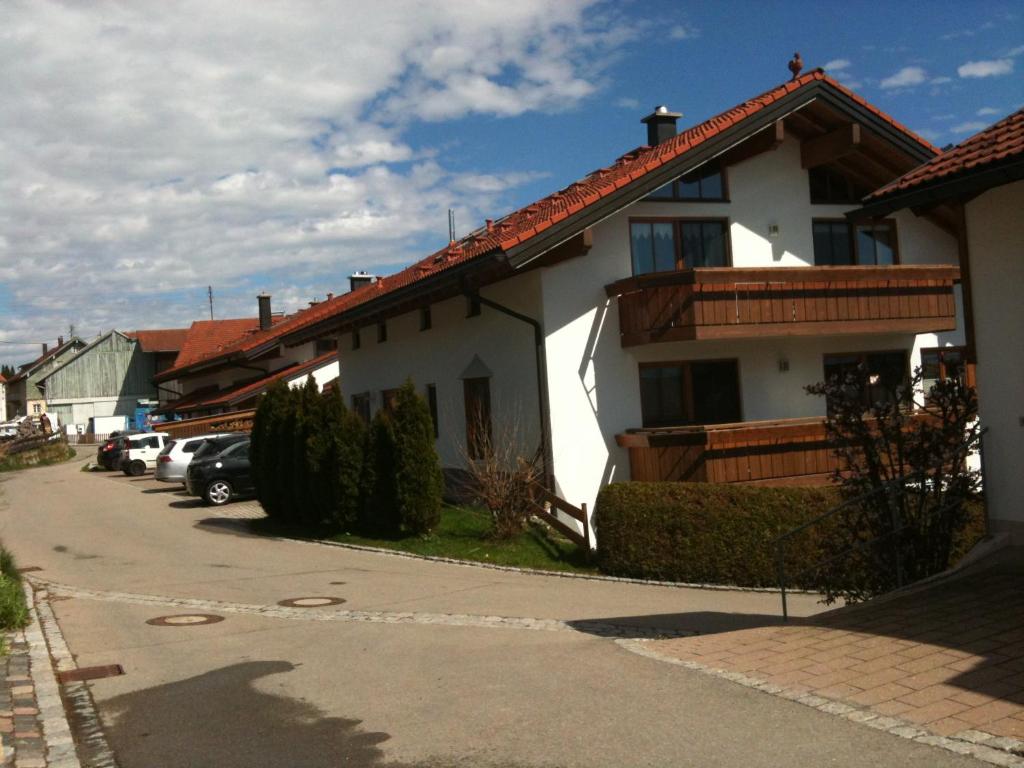 ein weißes Haus mit rotem Dach auf einer Straße in der Unterkunft Ferienwohnung Wiesner Annemarie in Rettenberg