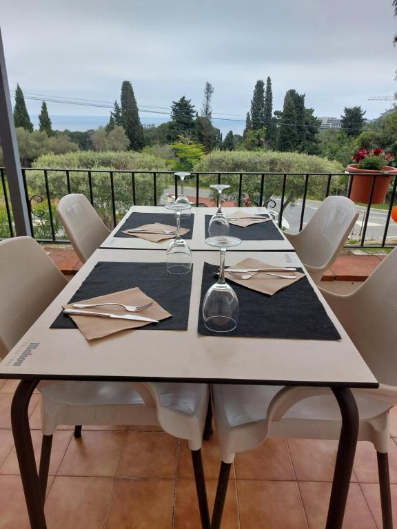 a white table with chairs and glasses on a balcony at Hotel Nuevo Ondina in Begur