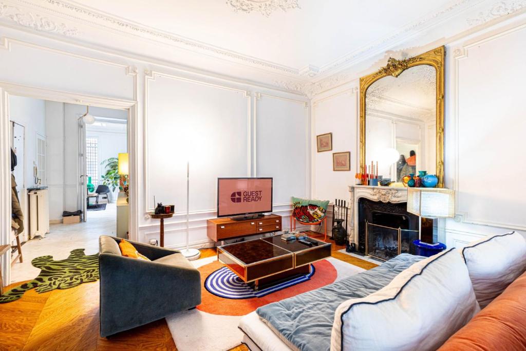 Una sala de estar con un sofá y una chimenea. en GuestReady - Designer Stay in Boho Batignolles, en París
