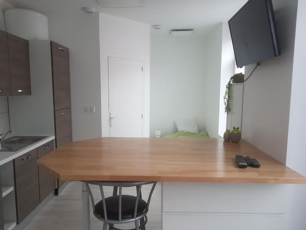 une cuisine avec un comptoir en bois dans une pièce dans l'établissement 1A studio à neuf Tout équipé, à Tourcoing