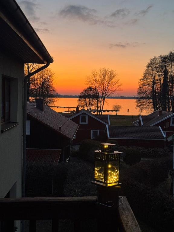 a lantern in front of a house with a sunset at Happy Place am Plauer See in Zislow