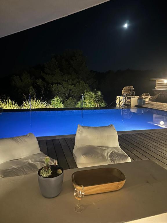 une table avec deux lits sur un balcon la nuit dans l'établissement Somptueuse Villa d'architecte climatisée avec Piscine chauffée, à Bandol