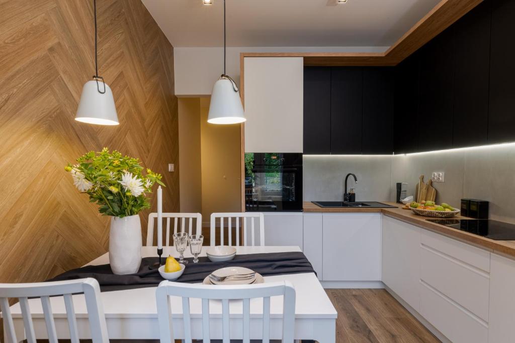 een keuken met een witte tafel en witte stoelen bij Cozy Corner by Cozyplace in Krakau