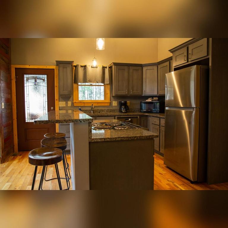 a kitchen with a stainless steel refrigerator and wooden cabinets at Evergreen - by The Chalets in Laurelville