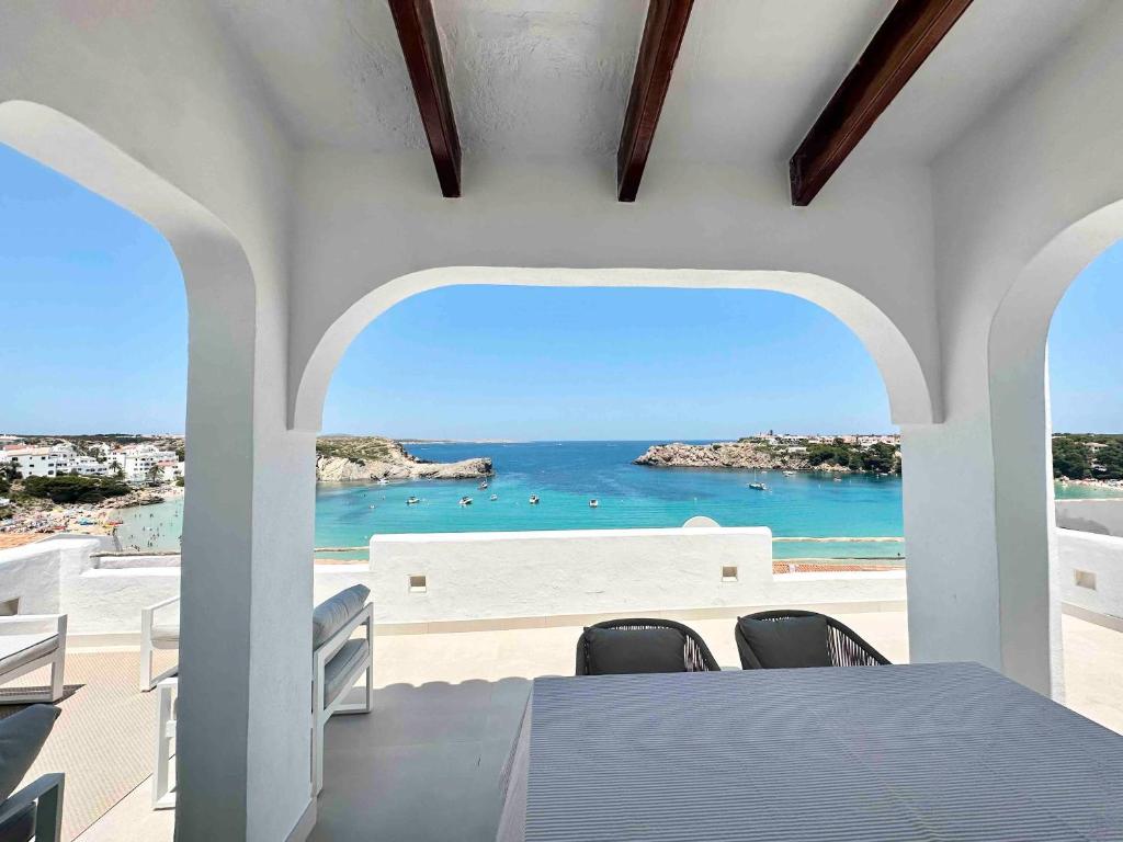 a dining room with a table and a view of the ocean at Apartamento Poblado marinero in Arenal d'en Castell