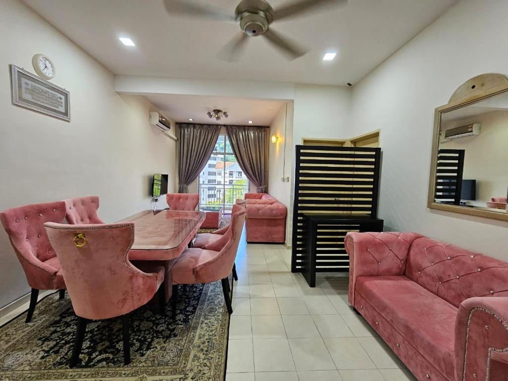 Una sala de estar con una mesa y sillas y un sofá. en Rosy Retreat, en Tambun