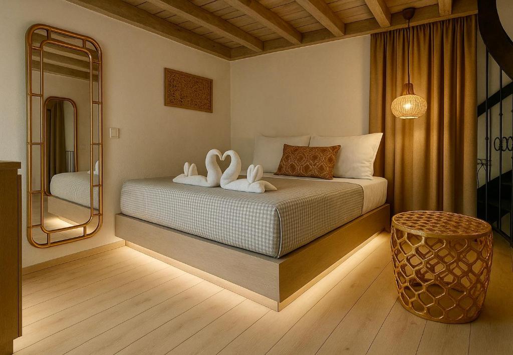 een slaapkamer met een bed en 2 zwanenhanddoeken bij Heliareti Traditional House in Koskinou