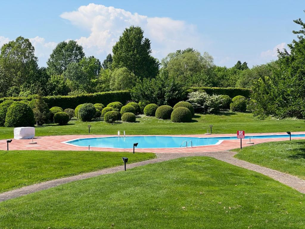 a swimming pool in the middle of a park at Terme Colli Golf - Suite La Montecchia in Montecchia