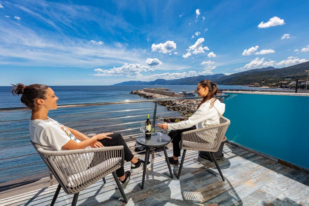 two women sitting at a table with a bottle of wine at La casa del pescatore in Cala Gonone