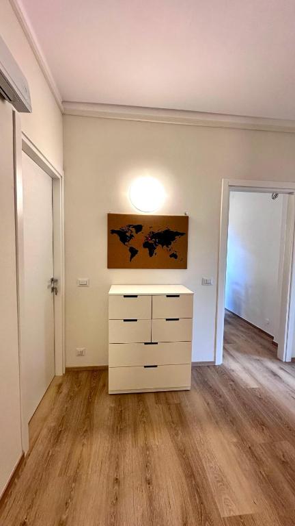 an empty living room with a dresser and a hallway at MarcOrio Apartment in Orio al Serio