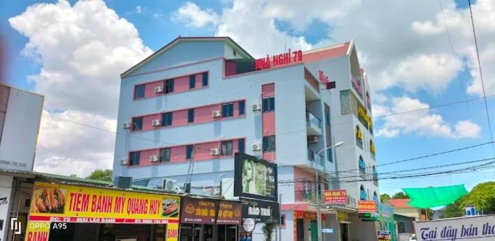 a large white building with red windows on a city street at Nhà nghỉ 79 in Ngô Xa