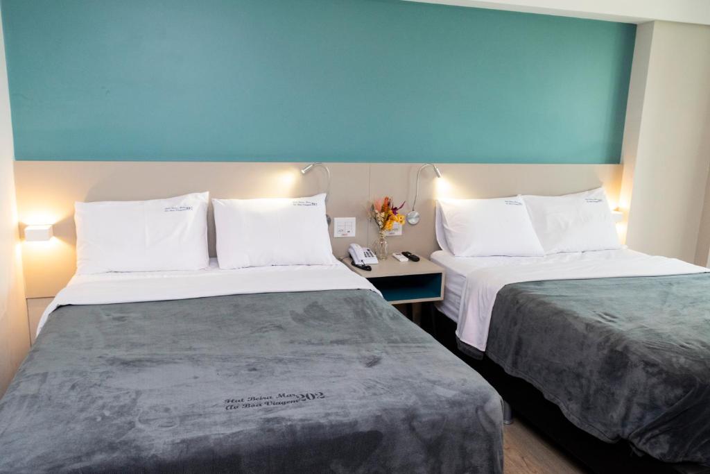2 łóżka w pokoju hotelowym z białymi poduszkami w obiekcie 202 Flat Beira Mar Av Boa viagem - Vista para o mar w mieście Recife