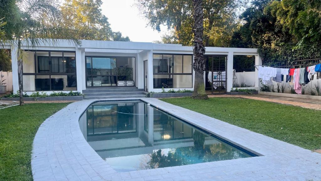a house with a swimming pool in the yard at Central Perk Guesthouse in Pretoria