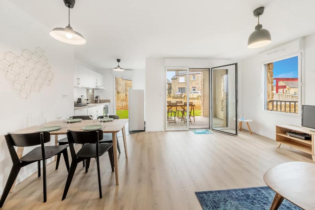 a kitchen and living room with a table and chairs at Bella Vista - Appartement 2 Chambres Moderne et Confortable in Saint-Coulomb