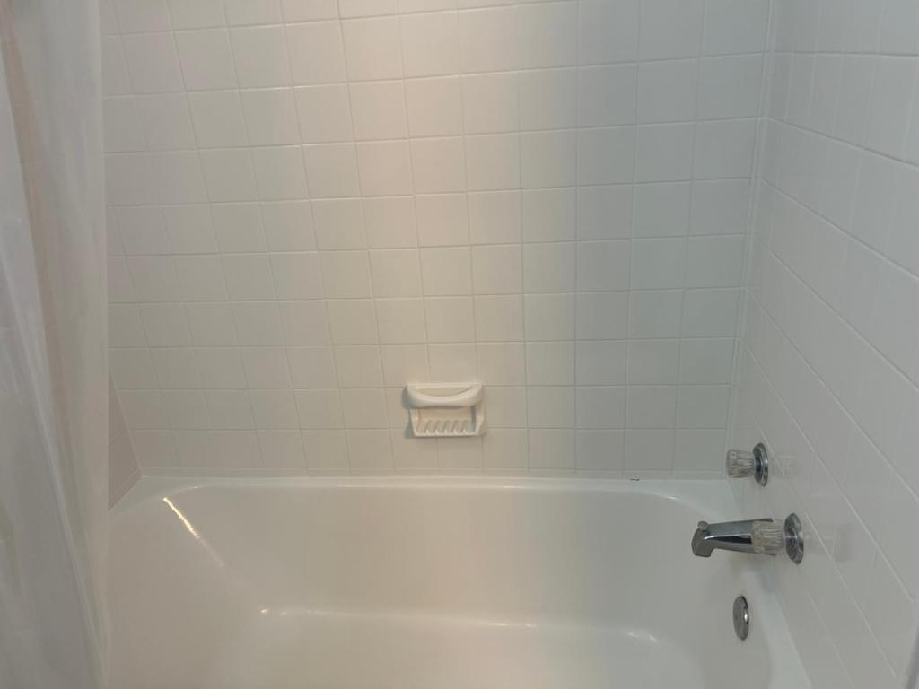 Una bañera blanca con grifo en un baño. en Queen Elizabeth Motel, en Elizabeth City
