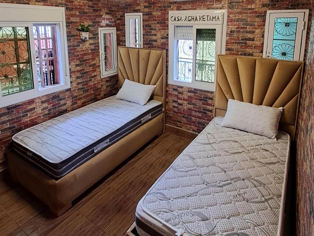 Ketama house vip في Igousdarene: سريرين في غرفة ذات نافذتين