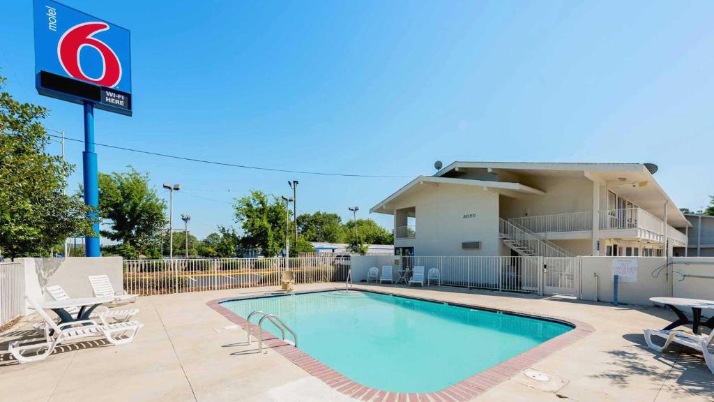 a pool at a hotel with chairs and a building at Motel 6-Columbus, GA in Columbus
