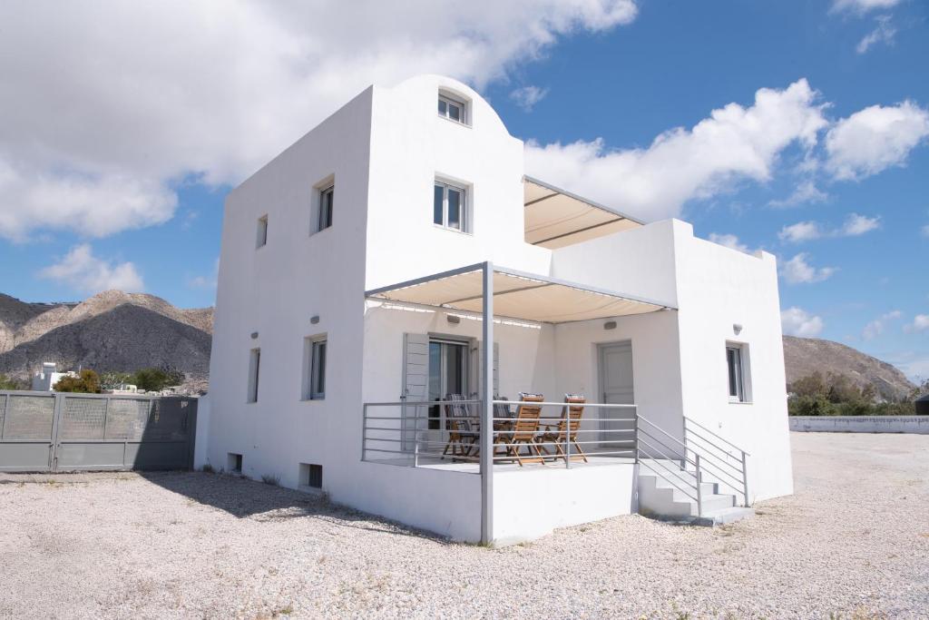 a white house with people sitting on the balcony at DENIS Summer Living in Perivolos
