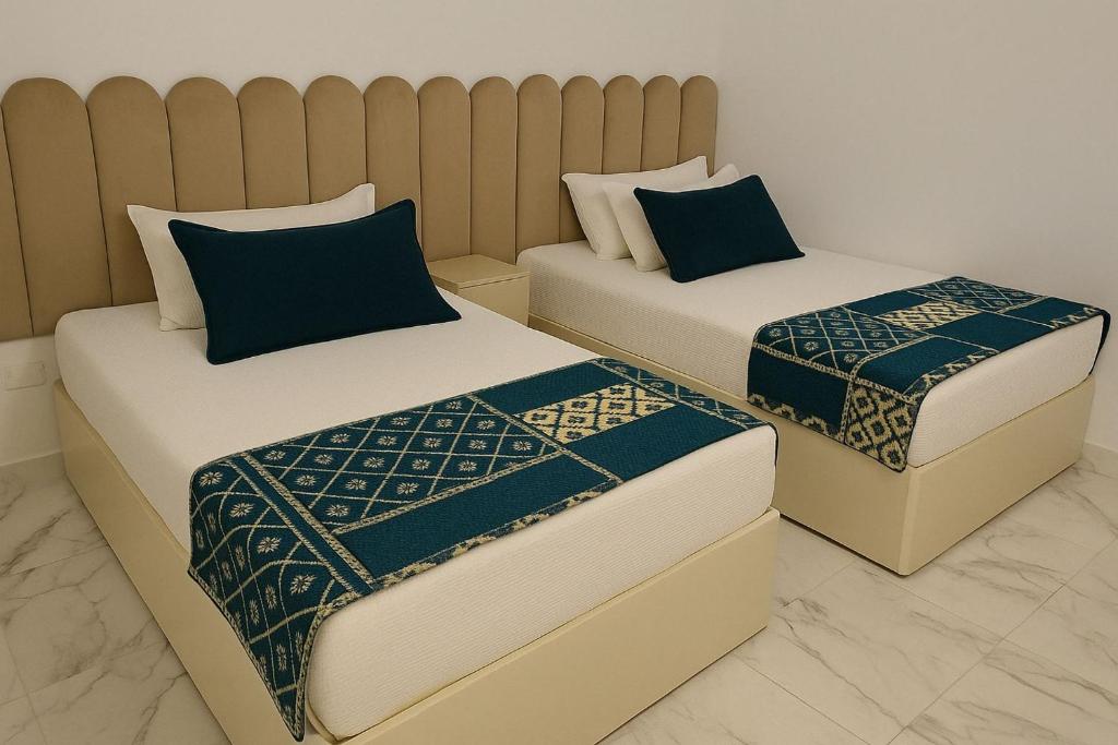 two beds sitting next to each other in a room at Seaside Bliss Getaway in Port Said