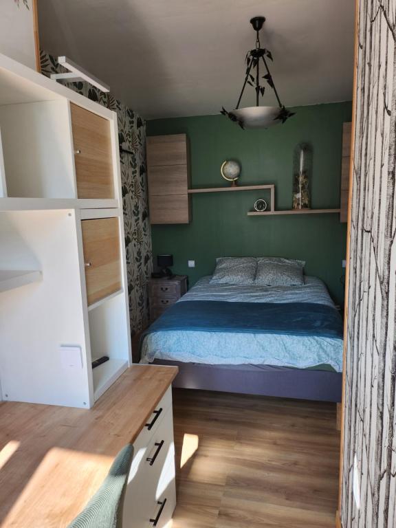 - une chambre avec un lit et des murs verts dans l'établissement Appartement à la campagne au calme, à La Celle-sous-Gouzon