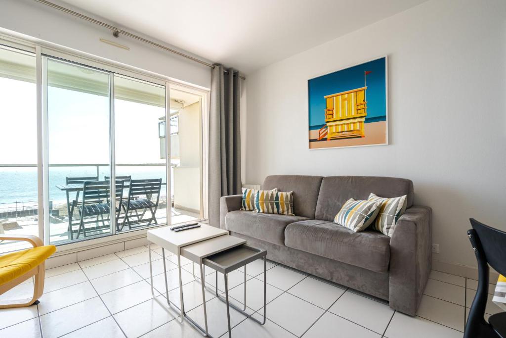 un salon avec un canapé et une vue sur l'océan dans l'établissement Ocean 90 face mer, à La Baule