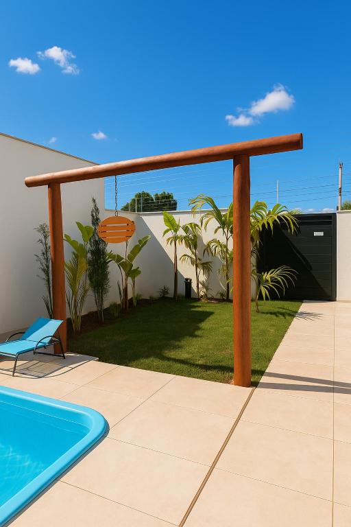 a patio with a swimming pool and a wooden pergola at Villa Oásis Espaço para eventos in Anápolis